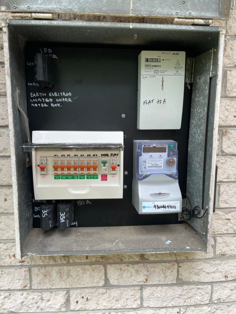 Open electrical panel on brick wall with circuit breakers and digital meter for Flat 35A