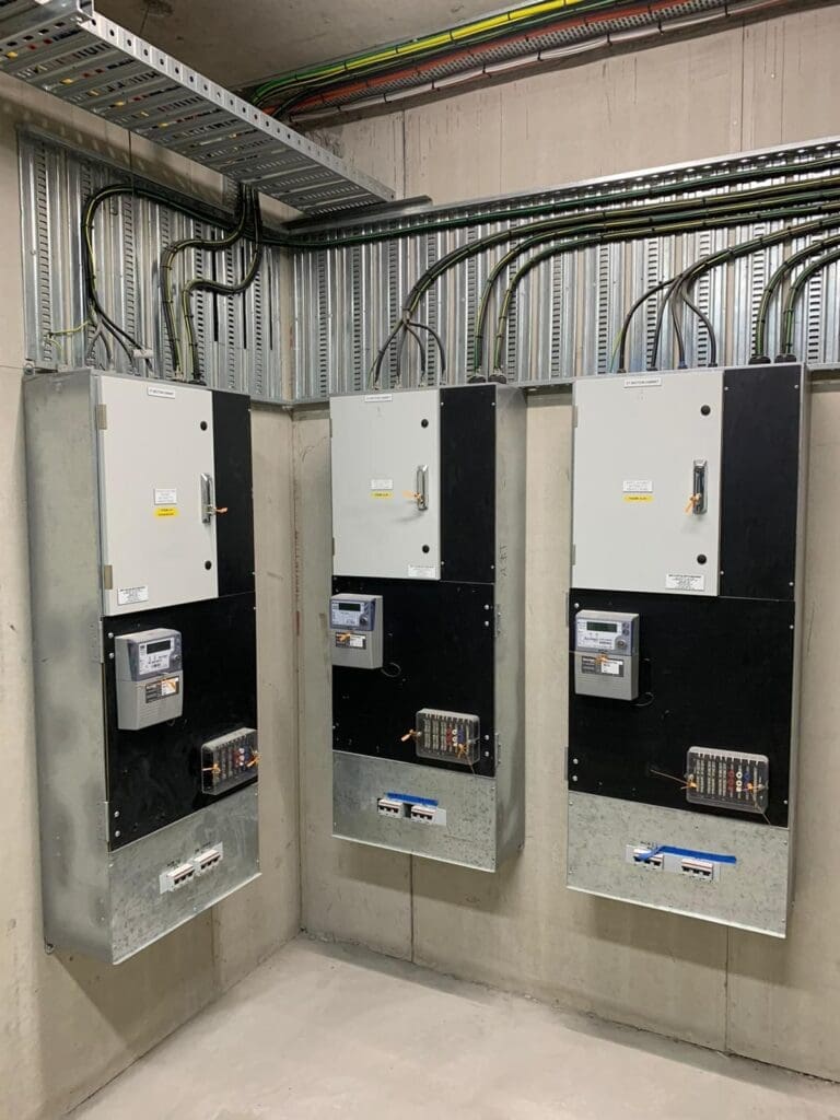 Industrial electrical panels mounted on a concrete wall with organised conduits in a commercial facility