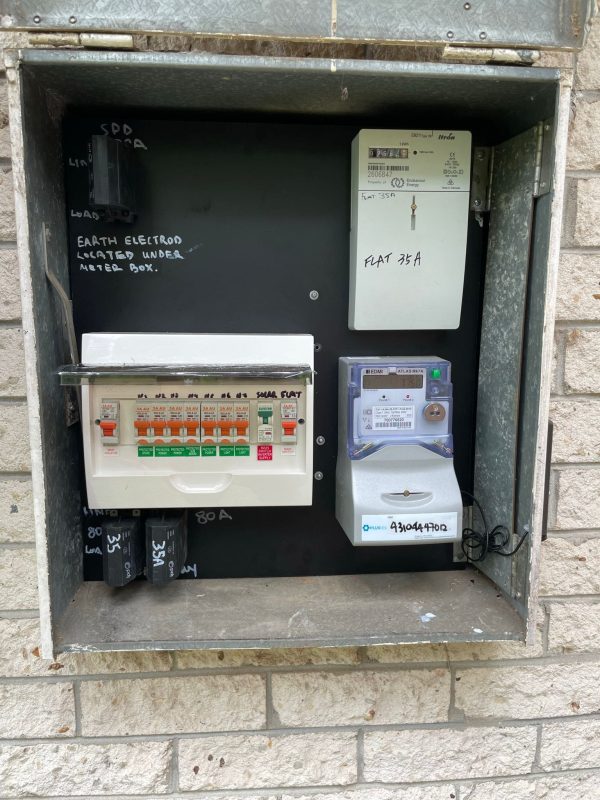 Electrical Panel Detail Open electrical panel on brick wall with circuit breakers and digital meter for Flat 35A