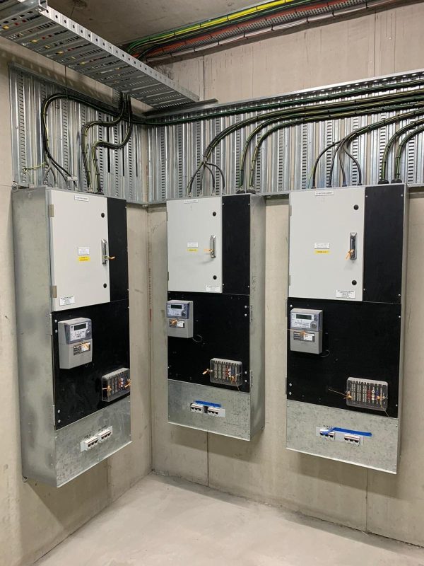 Advanced Electrical Panel Installation Industrial electrical panels mounted on a concrete wall with organised conduits in a commercial facility