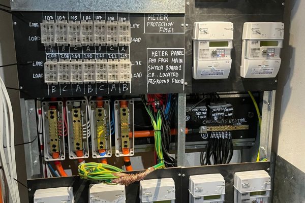 Advanced switchboard with detailed labelling of circuit breakers, meters, and fuses in an industrial setting