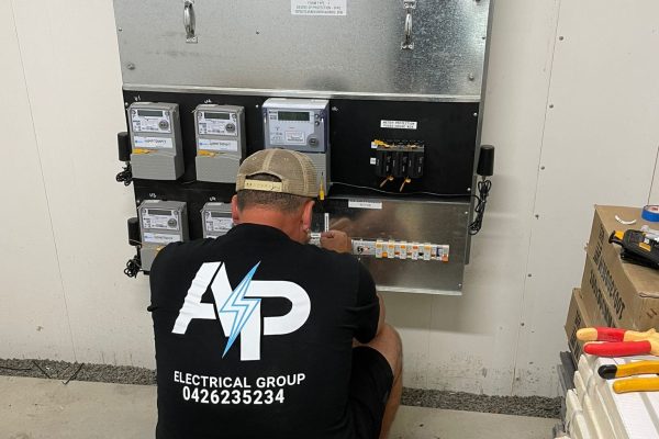 An AP Electrical Group electrician performing a switchboard upgrade installation in an industrial setting